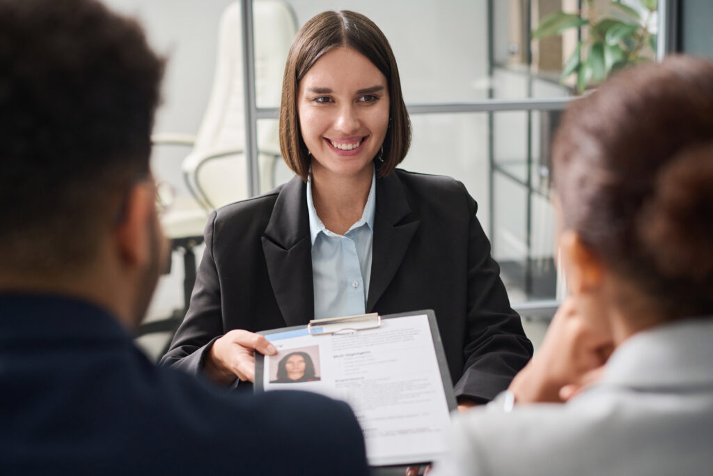 Poised candidate presents her resume with a bright, ready-to-start smile during one of her job interviews.